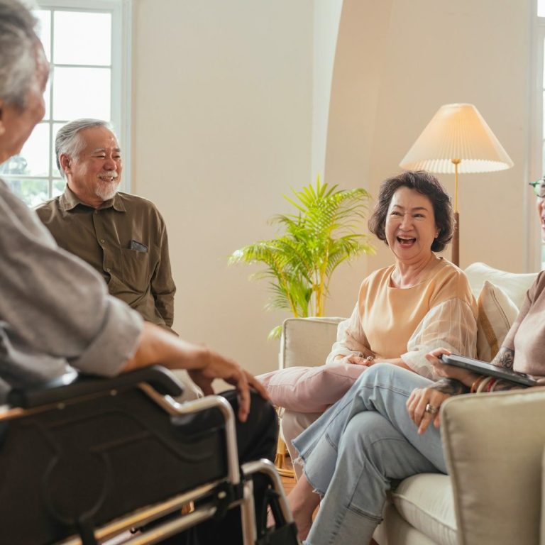 Gesprächsrunde Vier Personen sitzen im Kreis, eine Person im Rollstuhl. Es wird etwas besprochen.