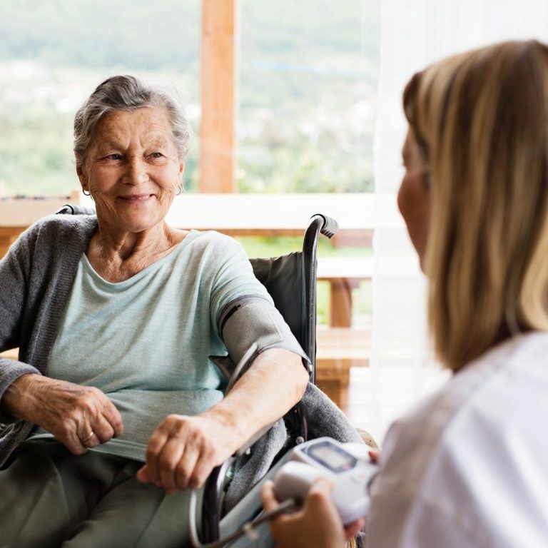 Blutdruckkontrolle Ältere Dame mit Pflegerin. Der Blutdruck wird gemessen.